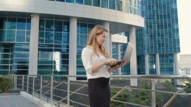 Şehir park iş merkezi içinde laptop üzerinde çalışan genç iş kadını