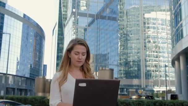 Молодая бизнесвумен работает на ноутбуке в бизнес-центре городского парка — стоковое видео