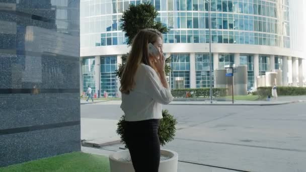 Jonge zakenvrouw praten is het gebruik van smartphone in park businesscentrum — Stockvideo
