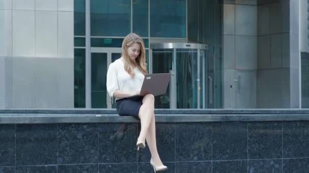 Young businesswoman working on laptop in city park business center — Stock Video