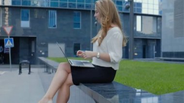 Şehir park iş merkezi içinde laptop üzerinde çalışan genç iş kadını
