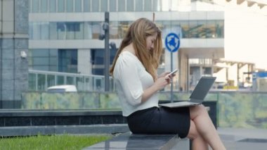 Şehir park iş merkezi içinde laptop üzerinde çalışan genç iş kadını