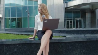 Şehir park iş merkezi içinde laptop üzerinde çalışan genç iş kadını