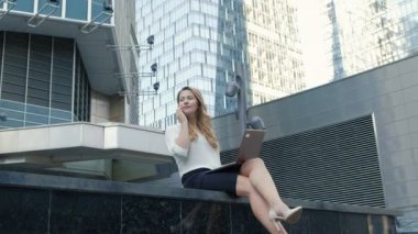 Şehir park iş merkezi içinde laptop üzerinde çalışan genç iş kadını