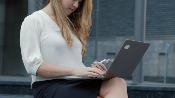 Şehir park iş merkezi içinde laptop üzerinde çalışan genç iş kadını — Stok video