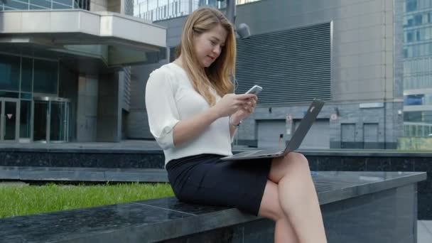 Jeune femme d'affaires travaillant sur ordinateur portable dans le centre d'affaires du parc de la ville — Video