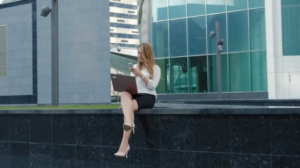 Young businesswoman working on laptop in city park business center — Stock Video