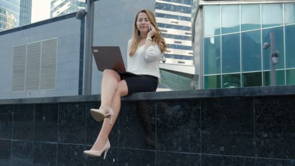 Young businesswoman working on laptop in city park business center — Stock Video