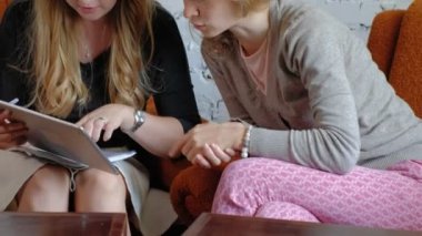 Ofiste bir touchpad kullanarak iki iş kadınları konularda tartışmaya meşgul