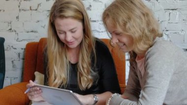 Ofiste bir touchpad kullanarak iki iş kadınları konularda tartışmaya meşgul