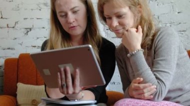 Ofiste bir touchpad kullanarak iki iş kadınları konularda tartışmaya meşgul