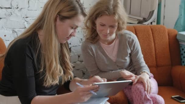 Due donne d'affari che usano un touchpad in ufficio sono impegnate a discutere di questioni — Video Stock