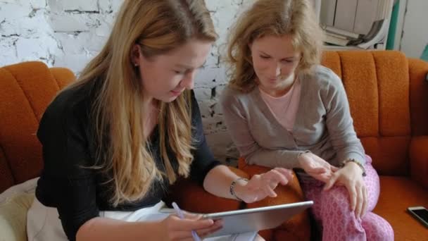 Zwei Geschäftsfrauen, die im Büro ein Touchpad benutzen, diskutieren eifrig — Stockvideo
