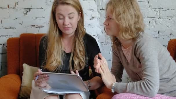 Due donne d'affari che usano un touchpad in ufficio sono impegnate a discutere di questioni — Video Stock