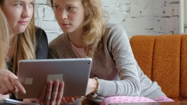 Twee zakelijke vrouwen met behulp van een touchpad in het kantoor zijn drukke aangelegenheden bespreekt — Stockvideo