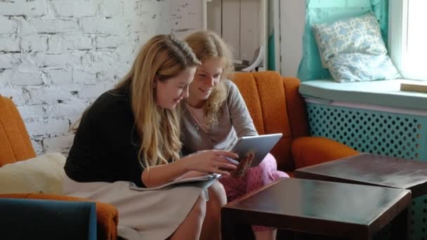 Duas mulheres de negócios usando um touchpad no escritório estão ocupadas discutindo assuntos — Vídeo de Stock