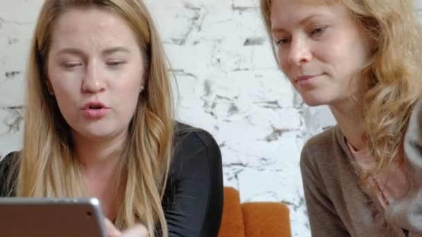 Deux femmes d'affaires utilisant un pavé tactile dans le bureau sont occupés à discuter des questions — Video