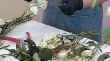 Çiçekçi bir buket çiçek satışı için hazırlar.