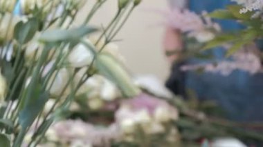 Çiçekçi bir buket çiçek satışı için hazırlar.