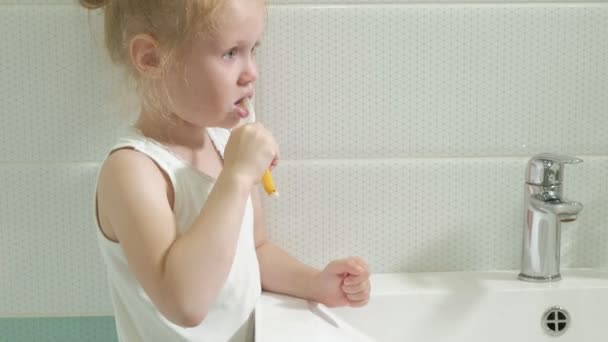 Niña lavándose diligentemente los dientes en el espejo . — Vídeos de Stock