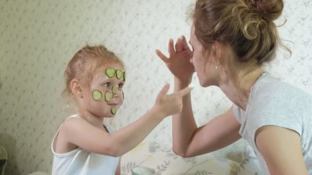 Eine Frau mit ihrer Tochter macht sich zu Hause über Gurkenmasken lustig — Stockvideo