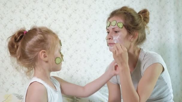 Bir kadın kızıyla birlikte salatalık maskesi evde eğlenceli hale getirir. — Stok video
