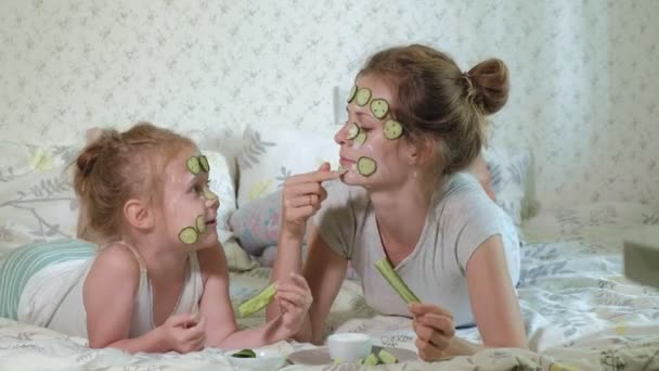 Eine Frau mit ihrer Tochter macht sich zu Hause über Gurkenmasken lustig — Stockvideo