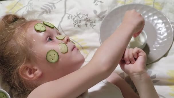 Uma mulher com sua filha faz troça de máscaras de pepino em casa — Vídeo de Stock