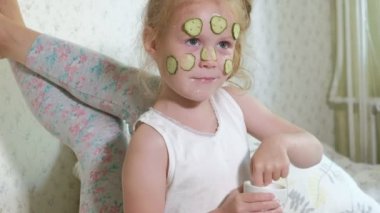 Bir kadın kızıyla birlikte salatalık maskesi evde eğlenceli hale getirir.