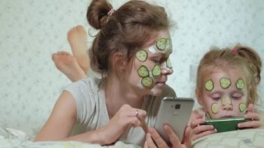 Bir kadın kızıyla birlikte salatalık maskesi evde eğlenceli hale getirir.