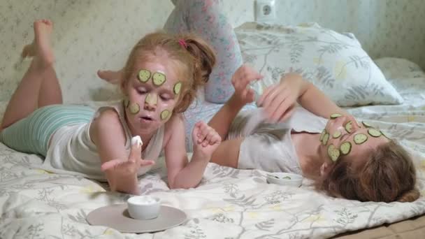 Una mujer con su hija se burla de las máscaras de pepino en casa — Vídeos de Stock