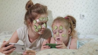 Bir kadın kızıyla birlikte salatalık maskesi evde eğlenceli hale getirir.