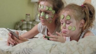 Bir kadın kızıyla birlikte salatalık maskesi evde eğlenceli hale getirir.