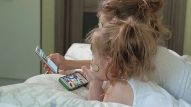 Bir kadın kızıyla birlikte salatalık maskesi evde eğlenceli hale getirir.