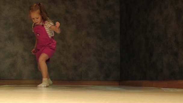 Giocare, saltando bambina in bianco con abito rosso gode gioco — Video Stock