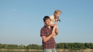 Baba ve kızı birlikte oynamaya yakın çekim. Genç bir baba kızı deniz kıyısında süper ağır çekim plajda dönüyor