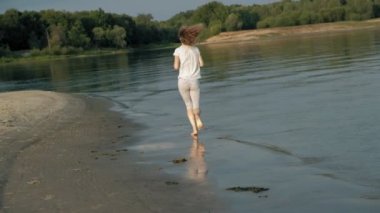 Anne ve kızı birlikte oynayan Close-up. Genç bir anne kızı deniz kıyısında süper ağır çekim plajda dönüyor