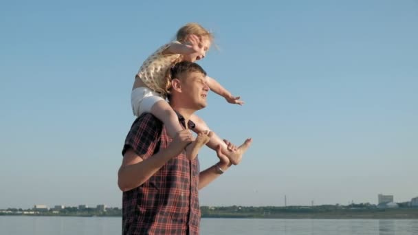 Nahaufnahme von Vater und Tochter beim gemeinsamen Spielen. ein junger vater dreht seine tochter am strand der meerküste superzeitlupe — Stockvideo