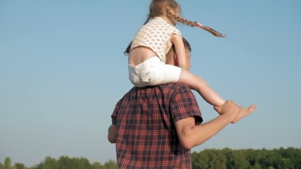 Close-up de pai e filha brincando juntos. Um jovem pai está girando sua filha na praia da costa do mar super câmera lenta — Vídeo de Stock