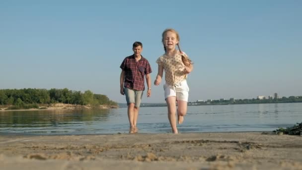 父と娘が一緒に遊ぶのクローズ アップ。若い父親が浜海岸超スローモーションの彼の娘を回転します。 — ストック動画