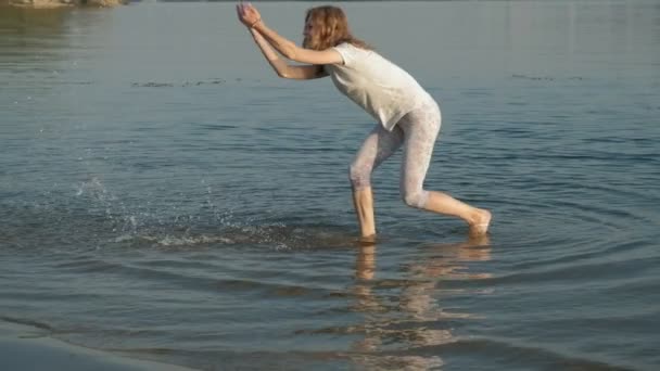 Close-up ibu dan anak bermain bersama. Seorang ibu muda berputar putrinya di pantai pantai yang super lambat gerak — Stok Video