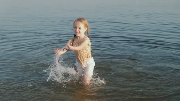 Mignon petit enfant heureux jouer et éclabousser dans les vagues de la mer, fille en bonne santé courir super ralenti — Video