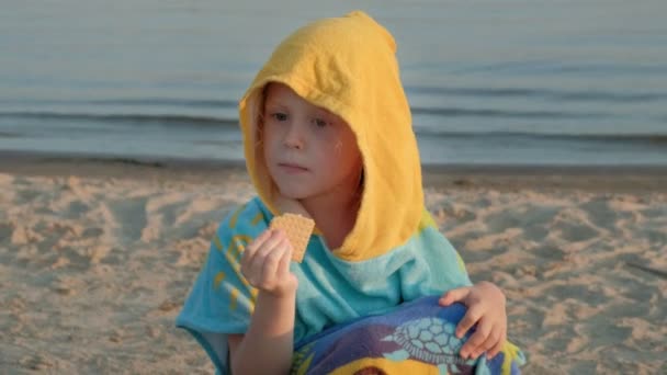 Szczęśliwa dziewczynka jedzenie biscuit plasterki na plaży. Lato wakacje piknik na świeżym powietrzu. — Wideo stockowe