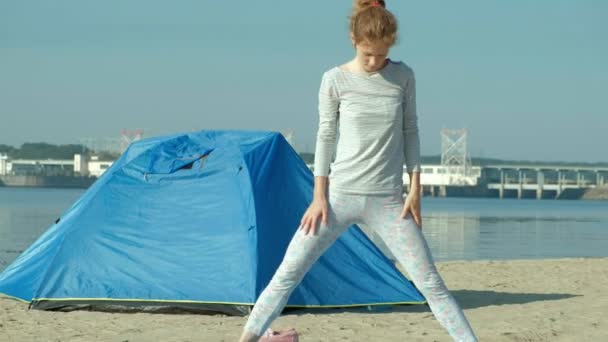 Schöne Frau, die Yoga auf See macht, Harmonie und Freiheit, Hintergrund vom Meer und sandblaues Touristenzelt, Konzept von Yoga und Frieden im Urlaub — Stockvideo