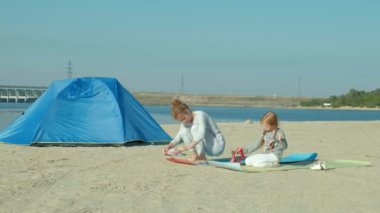 Anne ve kızı nişanlı yoga denizde, gülümseyen, arka plan mavi deniz suyu. Aile, anne ve kızı dostluk, tatil kavramı.
