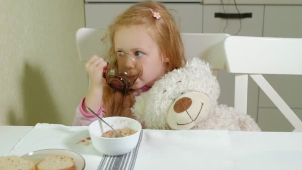 Bambina che mangia porridge in cucina a casa — Video Stock