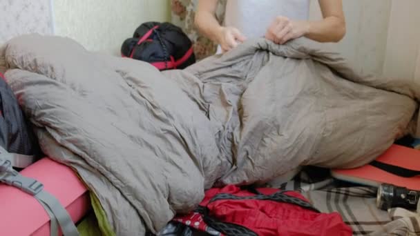 Una turista recoge cosas en una mochila en la cocina de la casa y se prepara para un viaje — Vídeo de stock