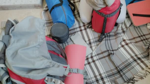 Bir kadın turist evin mutfağında bir sırt çantası içinde şeyler toplar ve bir gezi için hazırlar — Stok video