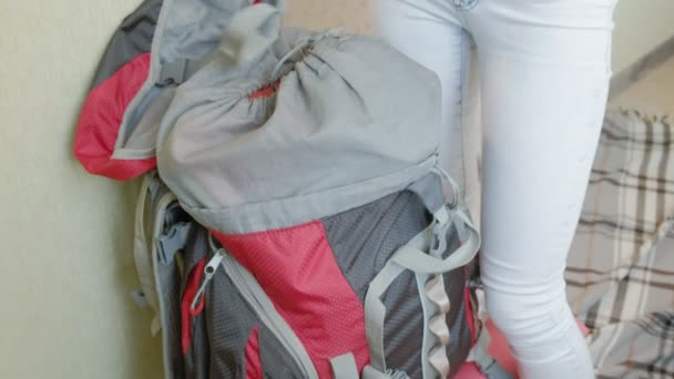 Bir kadın turist evin mutfağında bir sırt çantası içinde şeyler toplar ve bir gezi için hazırlar — Stok video