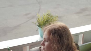 App akıllı kafe gülümseyen ve manifatura üstünde hareket eden telefon kullanan kadın. Güzel çok kültürlü genç casual kadın profesyonel üstünde hareket eden telefon